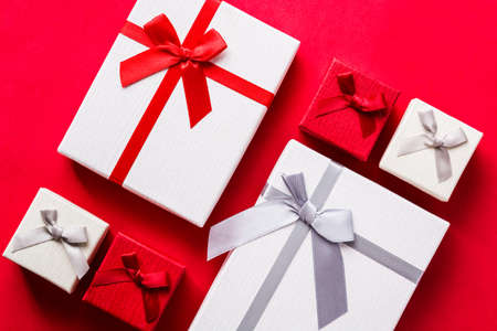 White and red gift boxes on red background. Top view.