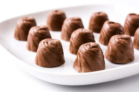 pieces of bonbons on white plate isolated on white backgroundの写真素材