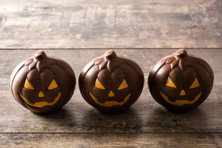 Chocolate Halloween pumpkins on wooden tableの写真素材
