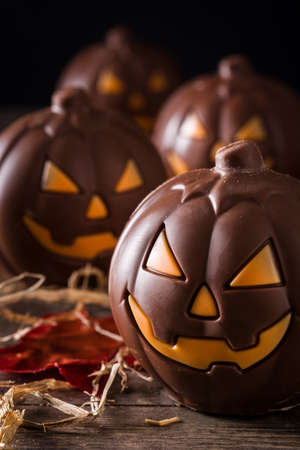 Chocolate Halloween pumpkins on wooden table and black backgroundの写真素材