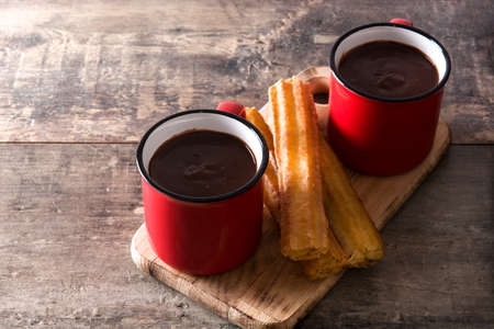 Hot chocolate with churros on wooden table
