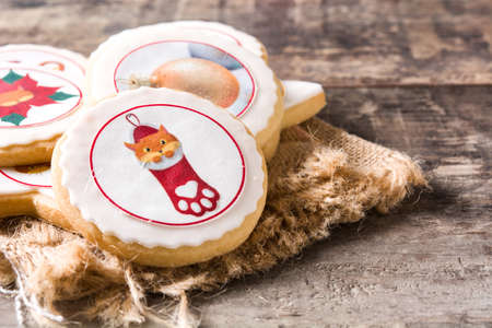 Homemade butter cookies with a printed Christmas design on wooden tableの写真素材
