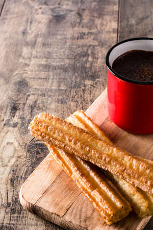Hot chocolate with churros on wooden tableの写真素材