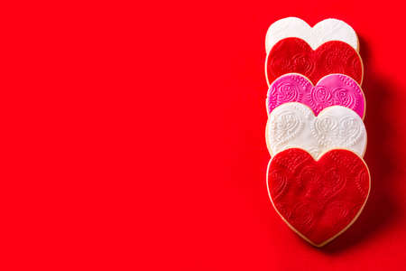 Heart-shaped cookies for Valentine's Day on red background. Copyspace