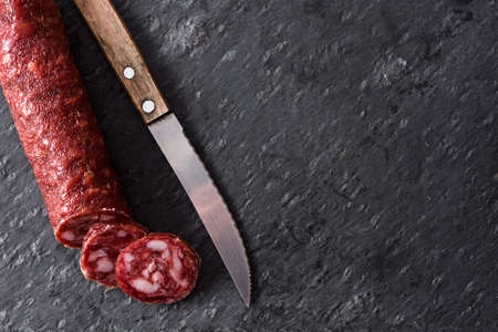 Cold meat sausage on black slate background. Top view. Copyspaceの写真素材