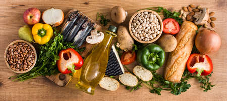 Healthy eating. Mediterranean diet. Fruit, vegetables, grain, nuts olive oil and fish on wooden...