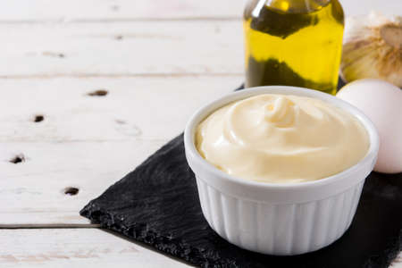 Aioli sauce and ingredients on white wooden tableの写真素材