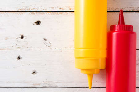 Ketchup and mustard bottles on white wooden background. Top view.Copyspaceの写真素材