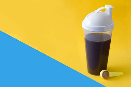 Chocolate protein shake on yellow and blue background