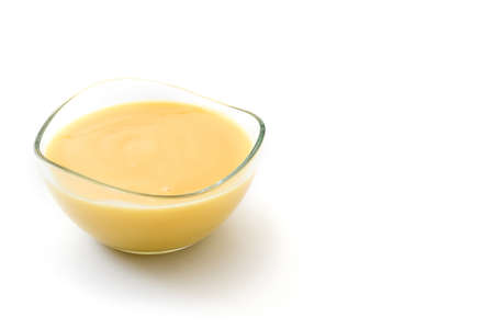 Bowl of homemade vanilla custard isolated on white background. Copyspace