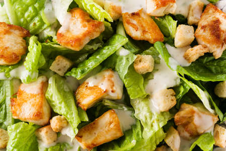Close up of caesar salad with lettuce, chicken and croutons isolated on white background.の写真素材