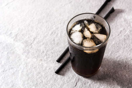 Soft drink cola glass for summer on gray background. Copyspace