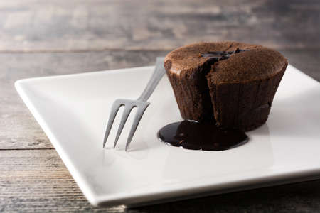 Coulant chocolate cake on wooden table. Copyspace