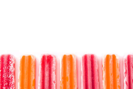 Orange and strawberry ice lollly pattern isolated on white background. Copyspace