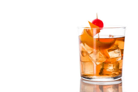 Old fashioned cocktail with orange and cherry isolated on white background. Copyspaceの写真素材