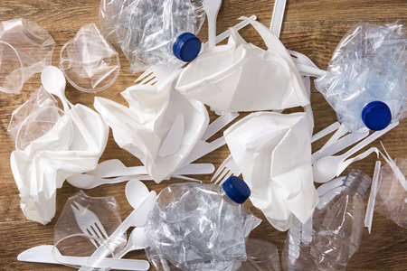Disposable waste plastic on wooden background. Top view