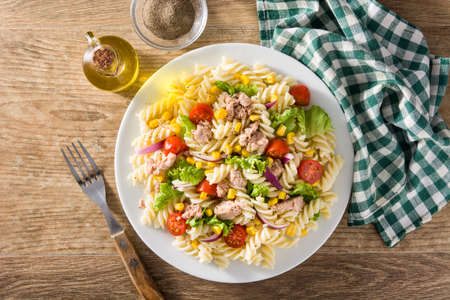 Pasta salad with vegetables and tuna on wooden table. Top viewの写真素材