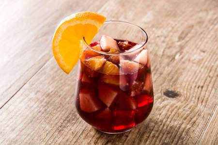 Red wine sangria in glass on wooden table.の写真素材
