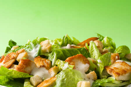 Caesar salad with lettuce, chicken and croutons on green background. Copyspaceの写真素材