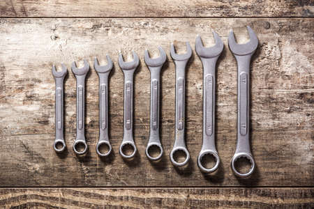 Wrenches of different sizes on wooden background. Top viewの写真素材
