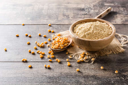 Corn flour in bowl on wooden tableの写真素材