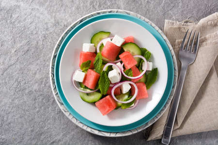 watermelon salad with feta cheese, mint, onion and cucumber on gray background.Top viewの写真素材