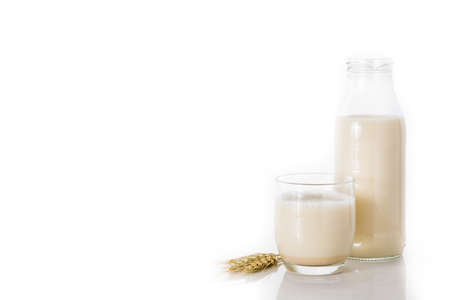 Oats milk in bottle and glass isolated on white backgroundの写真素材