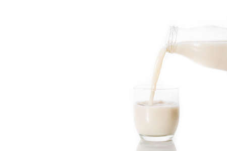 Oats milk in a bottle on wooden tableの写真素材