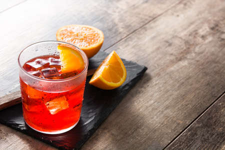 Negroni cocktail with piece of orange on wooden tableの写真素材