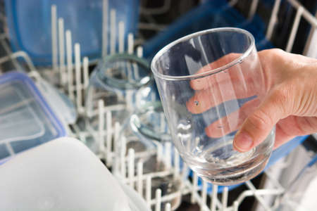 woman taking a glass out of the dishwasherの写真素材