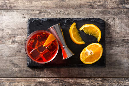Negroni cocktail with piece of orange in glass on wooden table. Top viewの写真素材