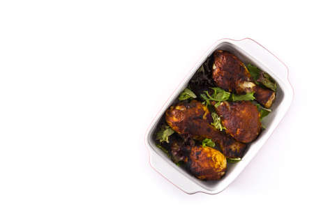 Roasted tandoori chicken with herbs isolated on white background. Top view. Copyspace