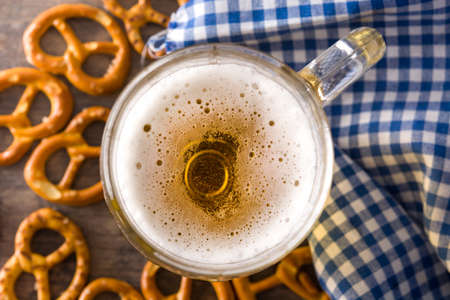 Beer with pretzels to celebrate Oktoberfest on wooden table. Top view