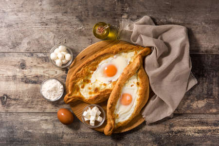 Traditional Adjarian Georgian khachapuri with cheese and egg on wooden table. Top viewの写真素材
