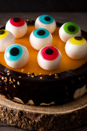 Halloween cake with candy eyes decoration on wooden table. Close upの写真素材