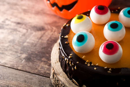 Halloween cake with candy eyes decoration on wooden table. Copyspaceの写真素材