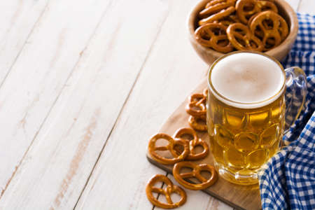 Oktoberfest beer and pretzel on white wooden table. Copyspace