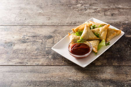 Samsa or samosas with meat and vegetables on wooden table. Traditional Indian food. Copyspaceの写真素材