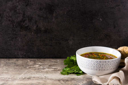 Indian lentil soup dal (dhal) in a bowl on wooden table. Copyspace