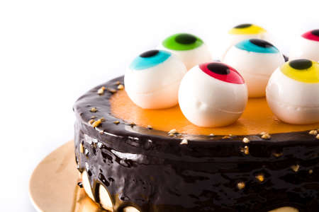Halloween cake with candy eyes decoration on white backgroundの写真素材