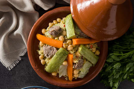 Traditional tajine with vegetables, chickpeas, meat and couscous on black slate. Top viewの写真素材