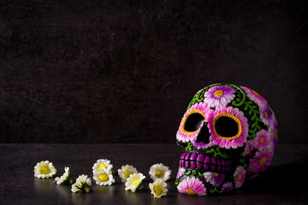 Typical Mexican skull painted and flowers on black background.Copyspace. Dia de los muertos.の写真素材