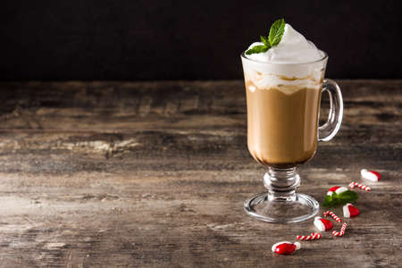 Peppermint coffee mocha for christmas on wooden table and black background. Copy spaceの写真素材