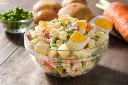 Traditional Russian salad in a bowl. Olivier salad on wooden tableの写真素材