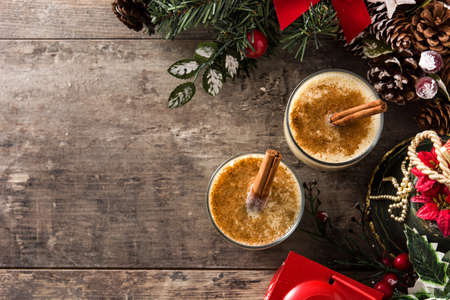 Homemade eggnog with cinnamon in glass on wooden table. Typical Christmas dessert. Copy spaceの写真素材