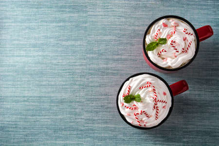 Peppermint coffee mocha decorated with candy canes for Christmas on blue background. Top view Copy spaceの写真素材