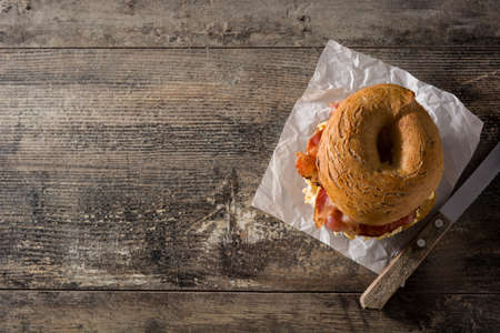Bagel sandwich with slab bacon, egg and cheese on wooden table. Top view Copy spaceの写真素材
