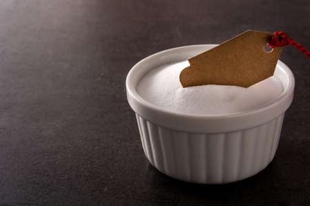 Baking soda in white bowl on black background. Copy spaceの写真素材