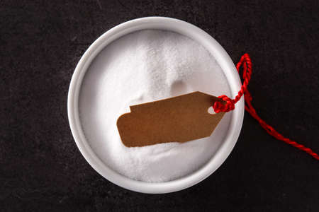 Baking soda in white bowl on black background. Top viewの写真素材