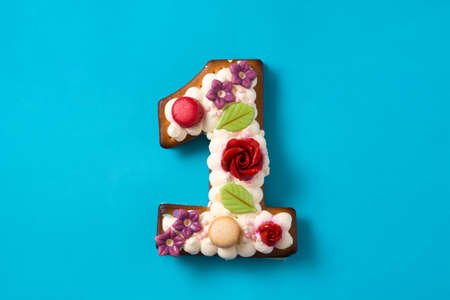 Number one cake decorated with flowers, macarons on blue backgroundの写真素材